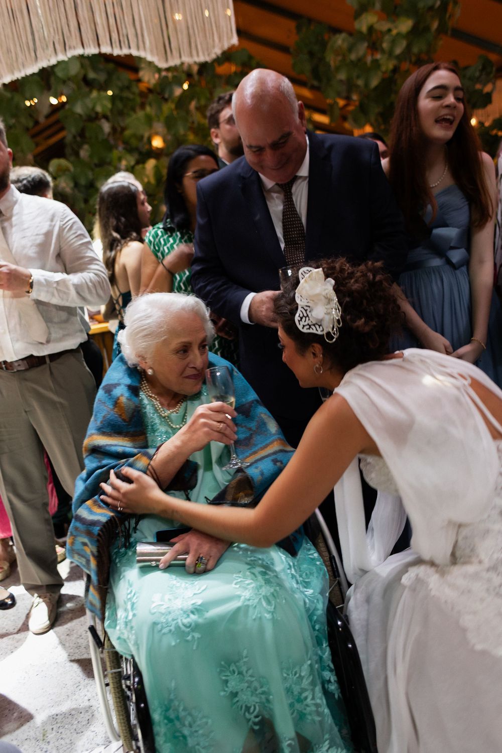 A person in a turquoise dress shares a special dance moment at a wedding reception.