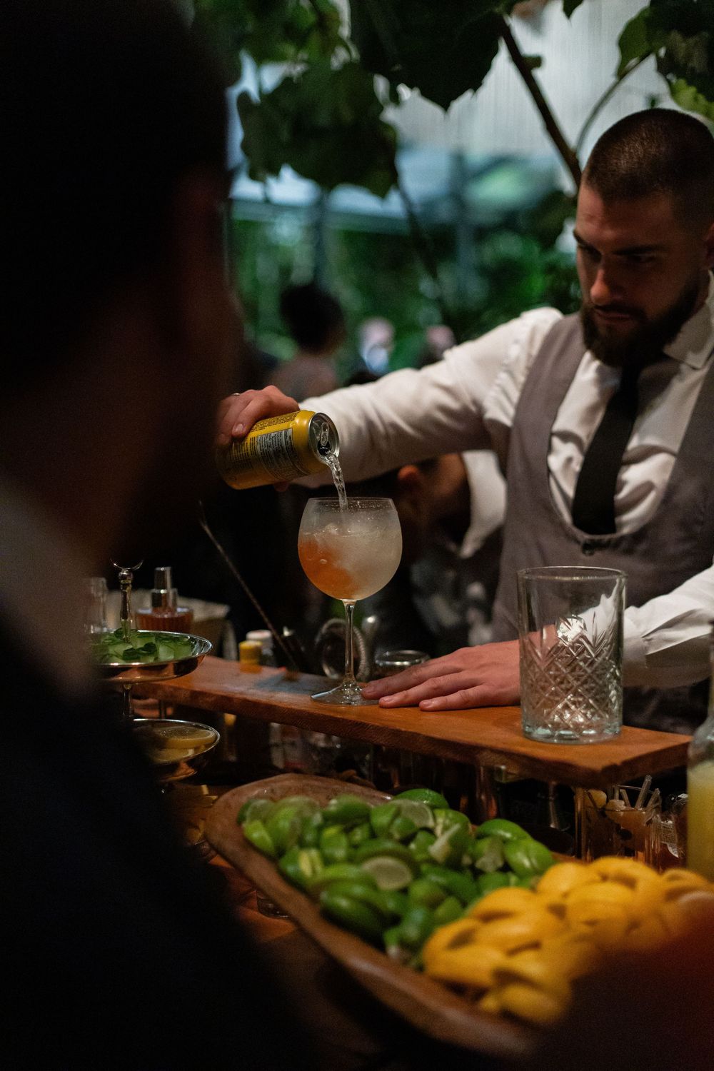 Bartender preparing cocktails with fresh citrus fruits at an elegant bar setup.