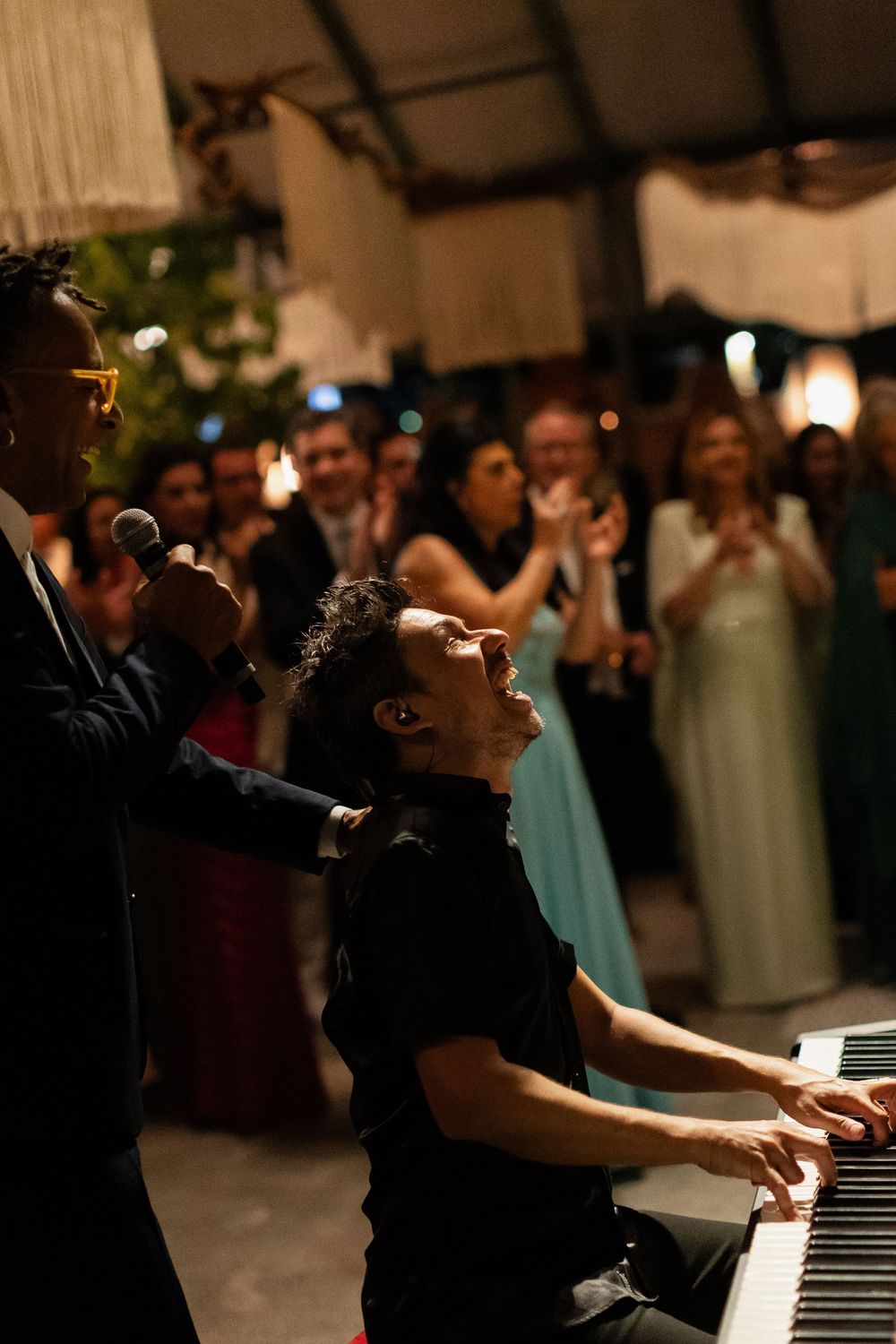 A musician plays piano during an intimate wedding reception performance.