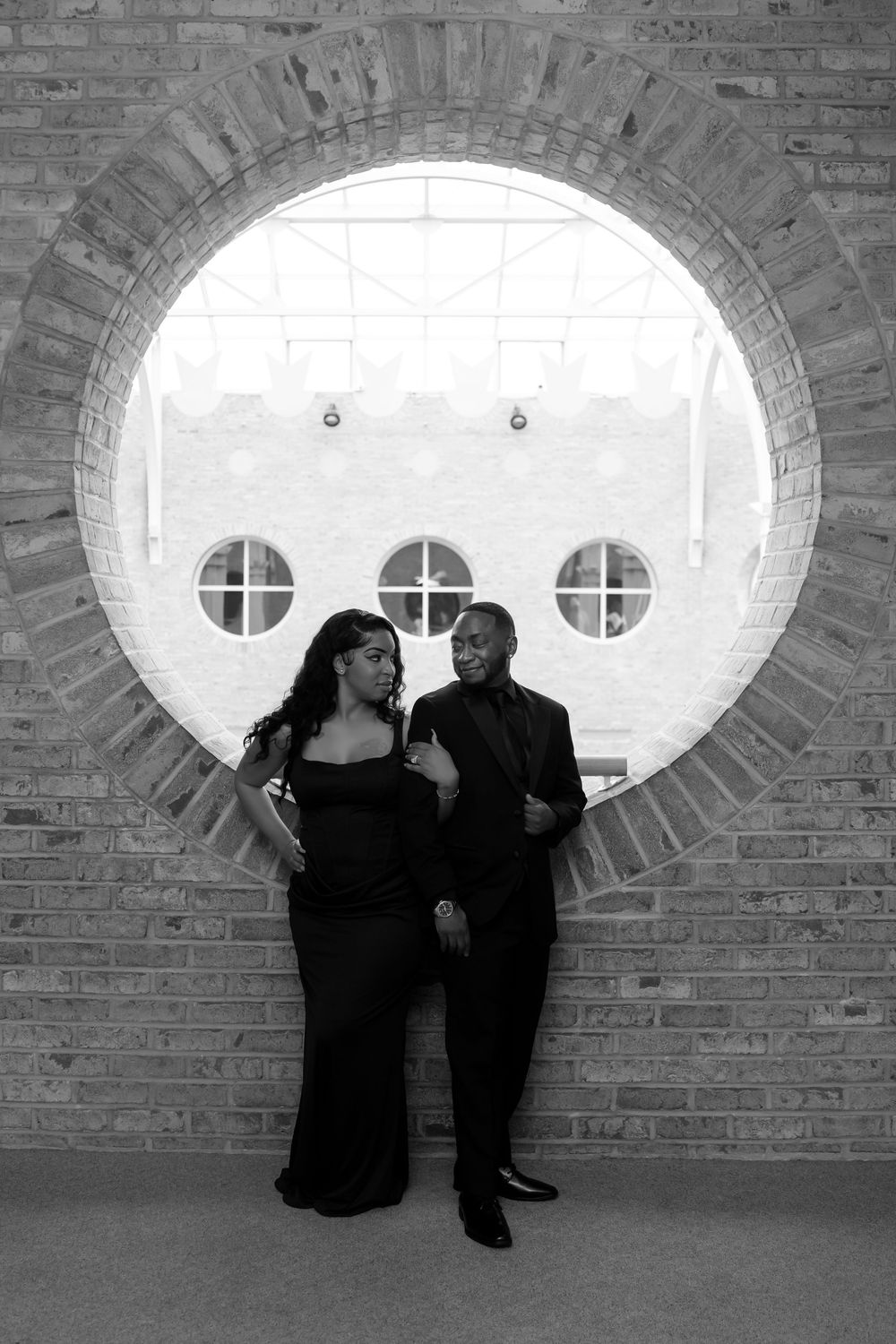 A series of black and white photos showing silhouettes sitting in an arched brick alcove with oval windows.