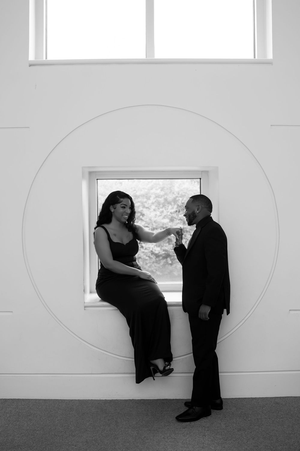 A series of black and white photos showing two dancers performing an expressive duet against a minimalist white wall.