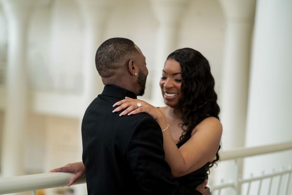 A joyful couple shares a romantic moment while dancing together at an elegant indoor venue.