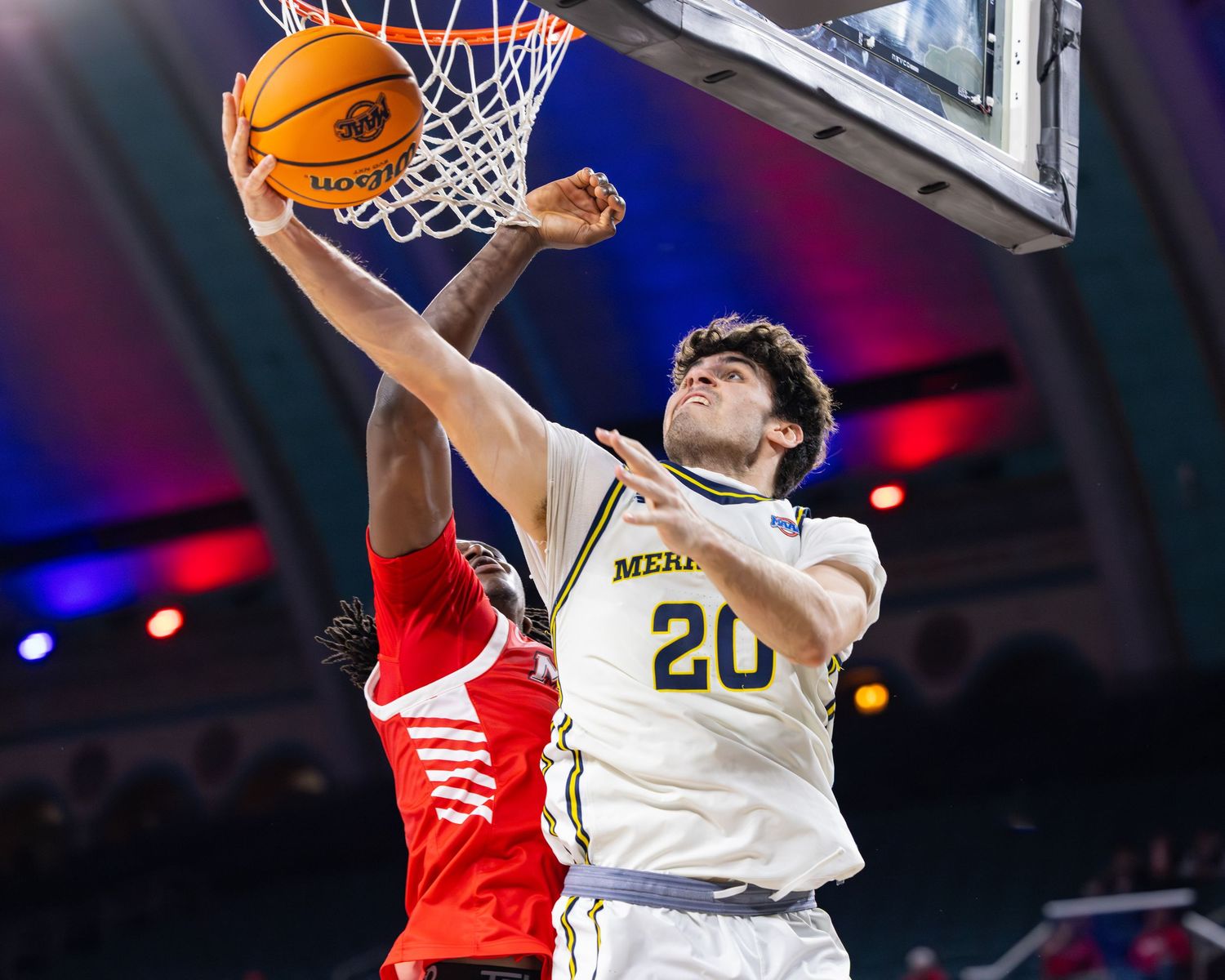 Basketball player in white jersey number 20 drives to the hoop for a layup.