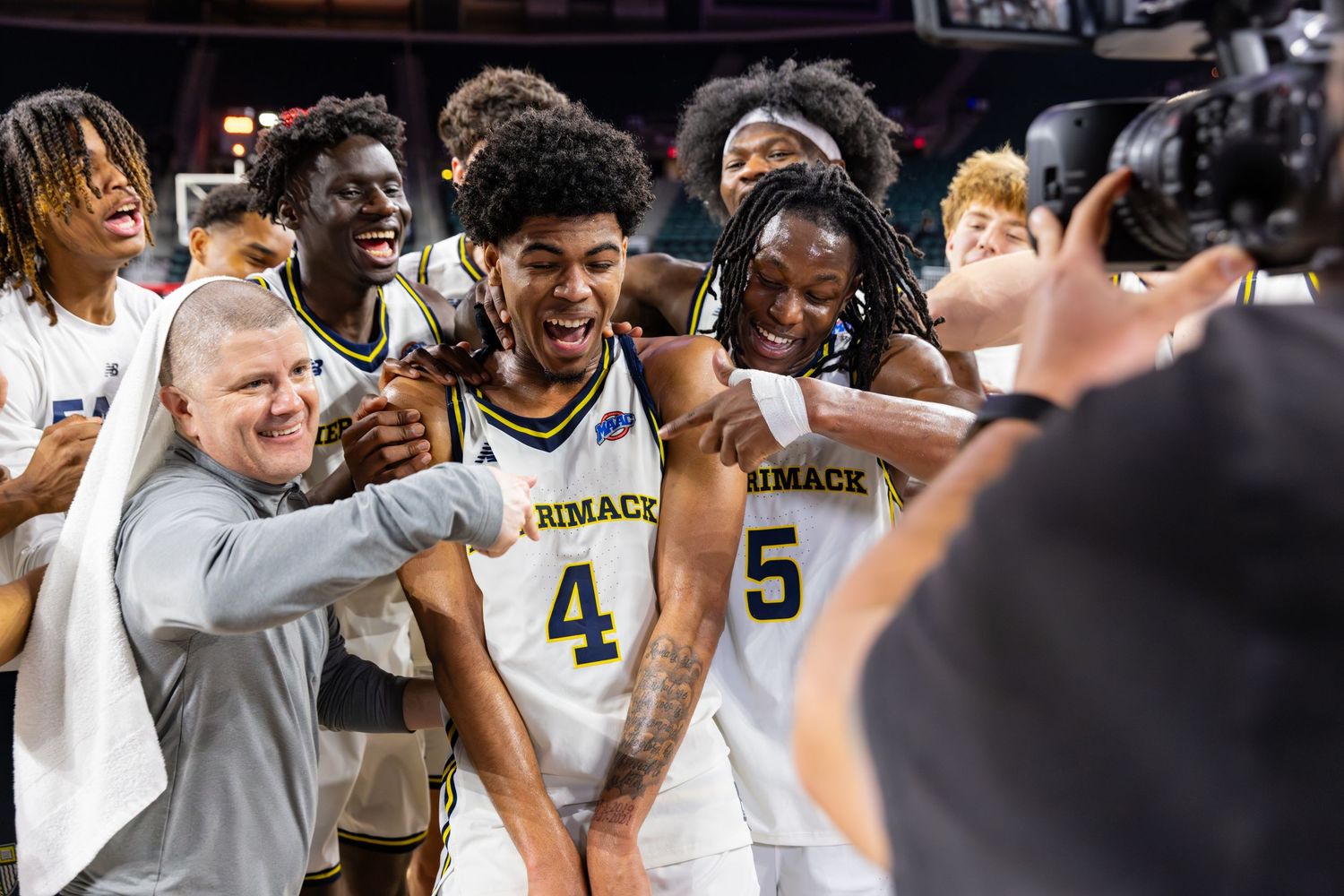 Basketball team celebrates together after victory on the court.