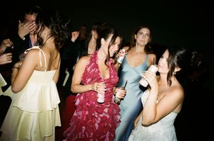 A group of people enjoying drinks and conversation at a dimly lit social gathering.