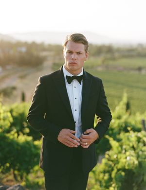 Formal black tuxedo detail shots against scenic vineyard backdrop at sunset.
