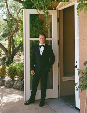 A series of white doorways and archways in a Mediterranean-style building with lush greenery overhead.