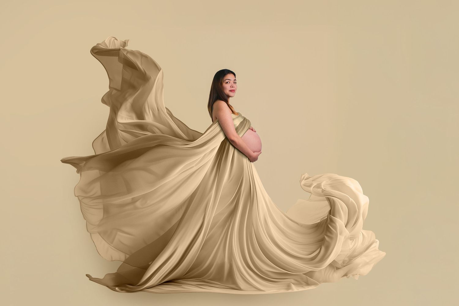 Flowing beige fabric billows and ripples gracefully in a series of dynamic sculptural forms against a neutral background.
