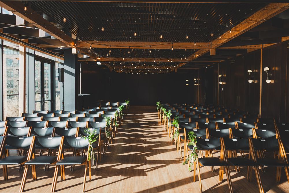 Modern district winery dc ceremony space with  natural light streaming through windows, creating dramatic shadows on dark floors.