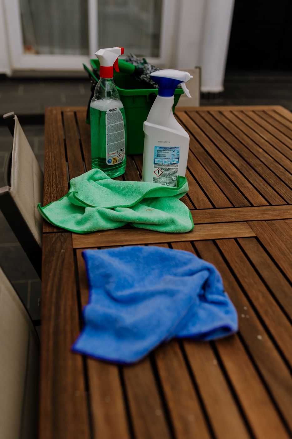 Cleaning window materials placed on a wood table outside.