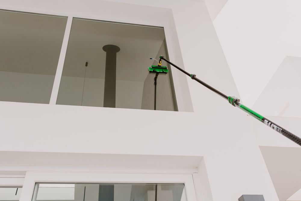 Photo of special high stick with a brash cleaning a high window crystals.