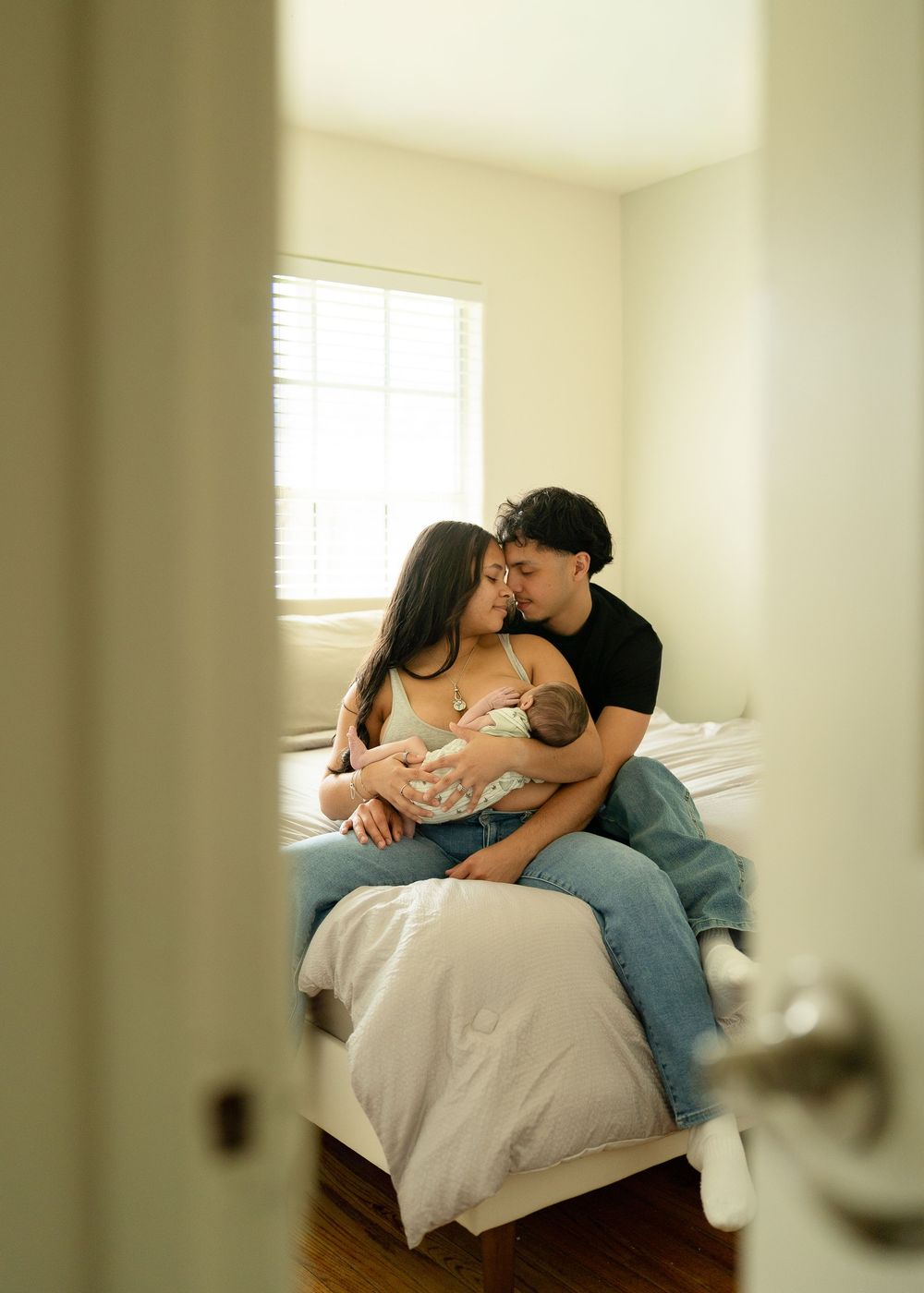 First-time parents cuddling newborn during relaxed Houston lifestyle session