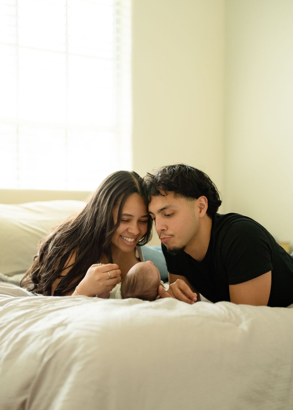 First-time parents cuddling newborn during relaxed Houston lifestyle session