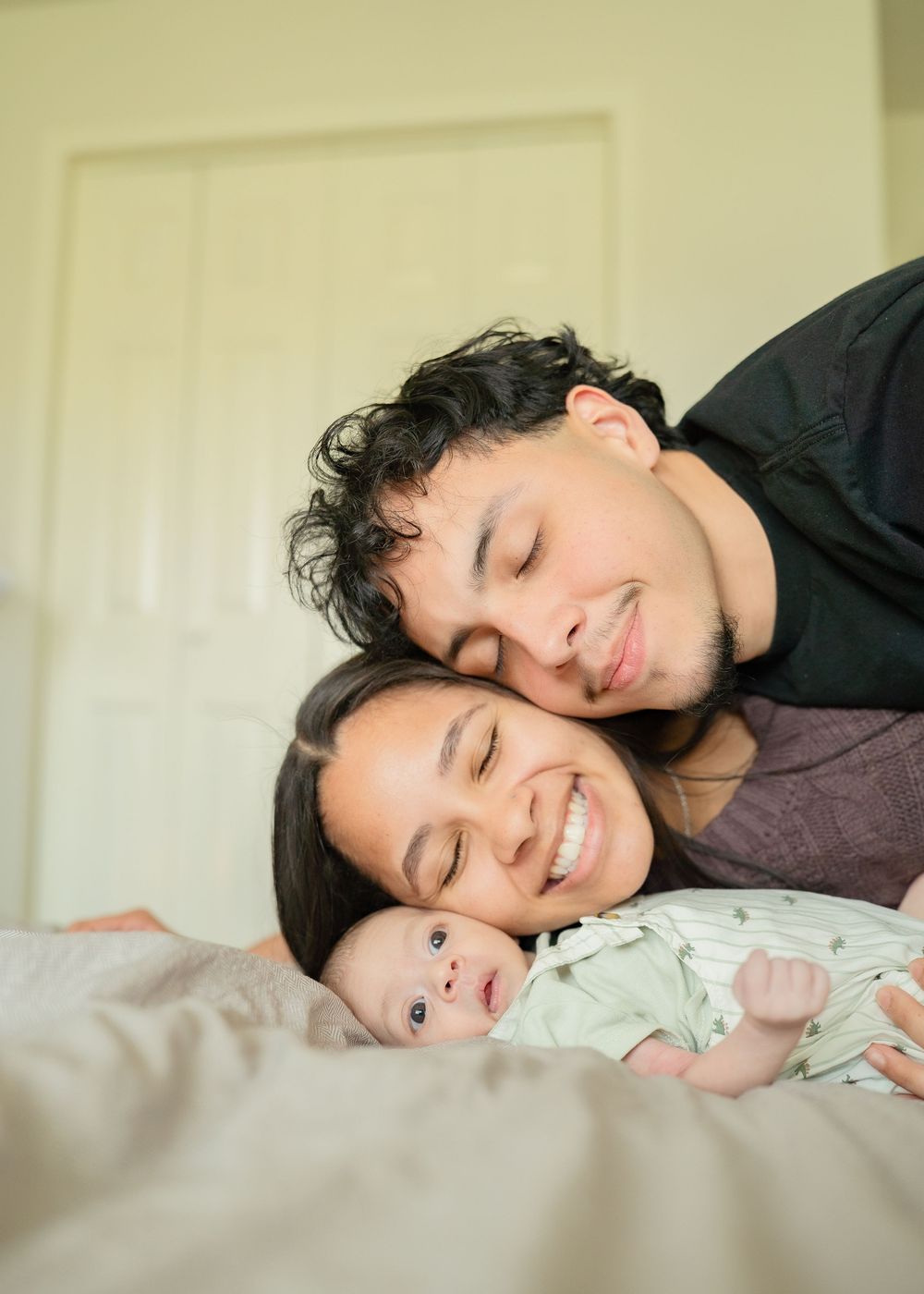 First-time parents cuddling newborn during relaxed Houston lifestyle session