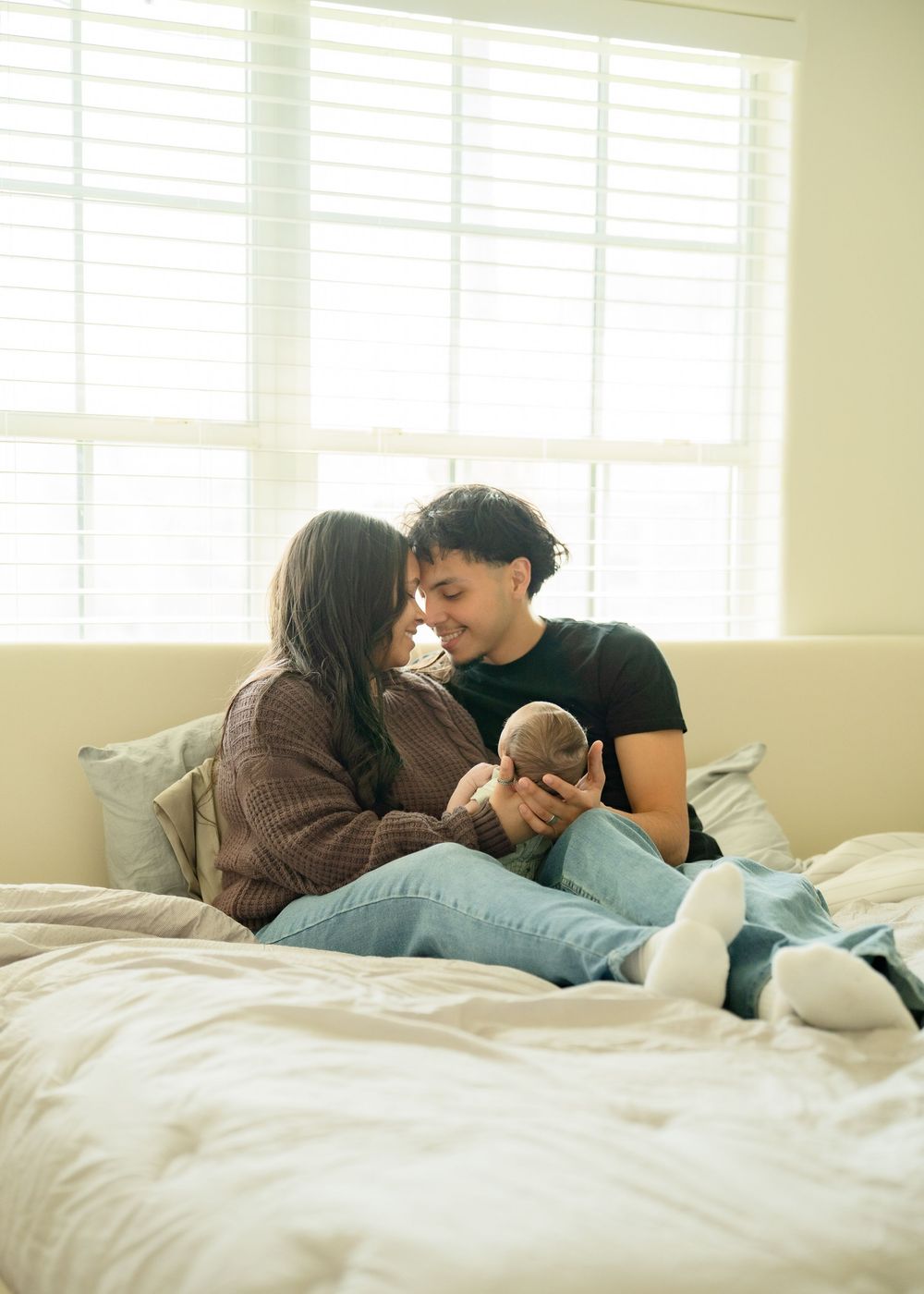 First-time parents cuddling newborn during relaxed Houston lifestyle session