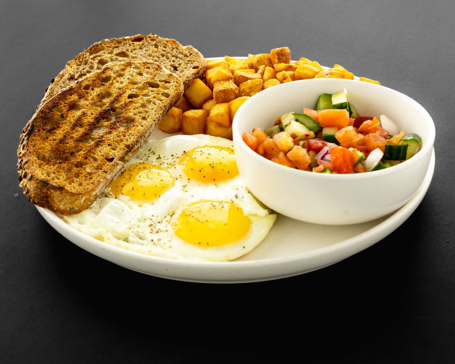 A sequence of breakfast plates showing sunny side up eggs with toast and various side dishes on white plates.