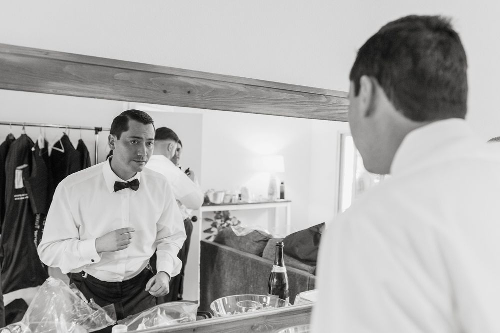 A black and white photo of a groom getting ready for his wedding day at The Oaks at Duncan Lane.