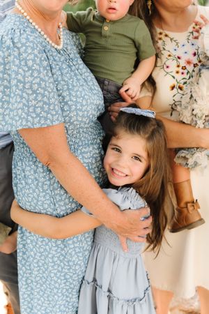 A tender family moment captured in soft natural light with floral clothing and gentle embraces in Saratoga Springs, Utah