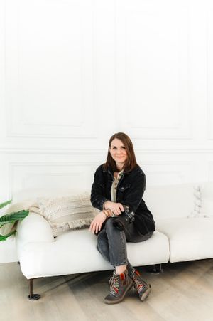 Casual portrait session against white wall with leather boots and black jacket.