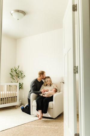 Minimalist indoor family photography session in a bright white room with natural light.