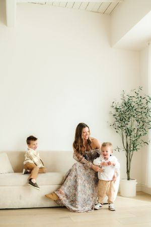 Modern family portrait in minimalist living room with potted plant.