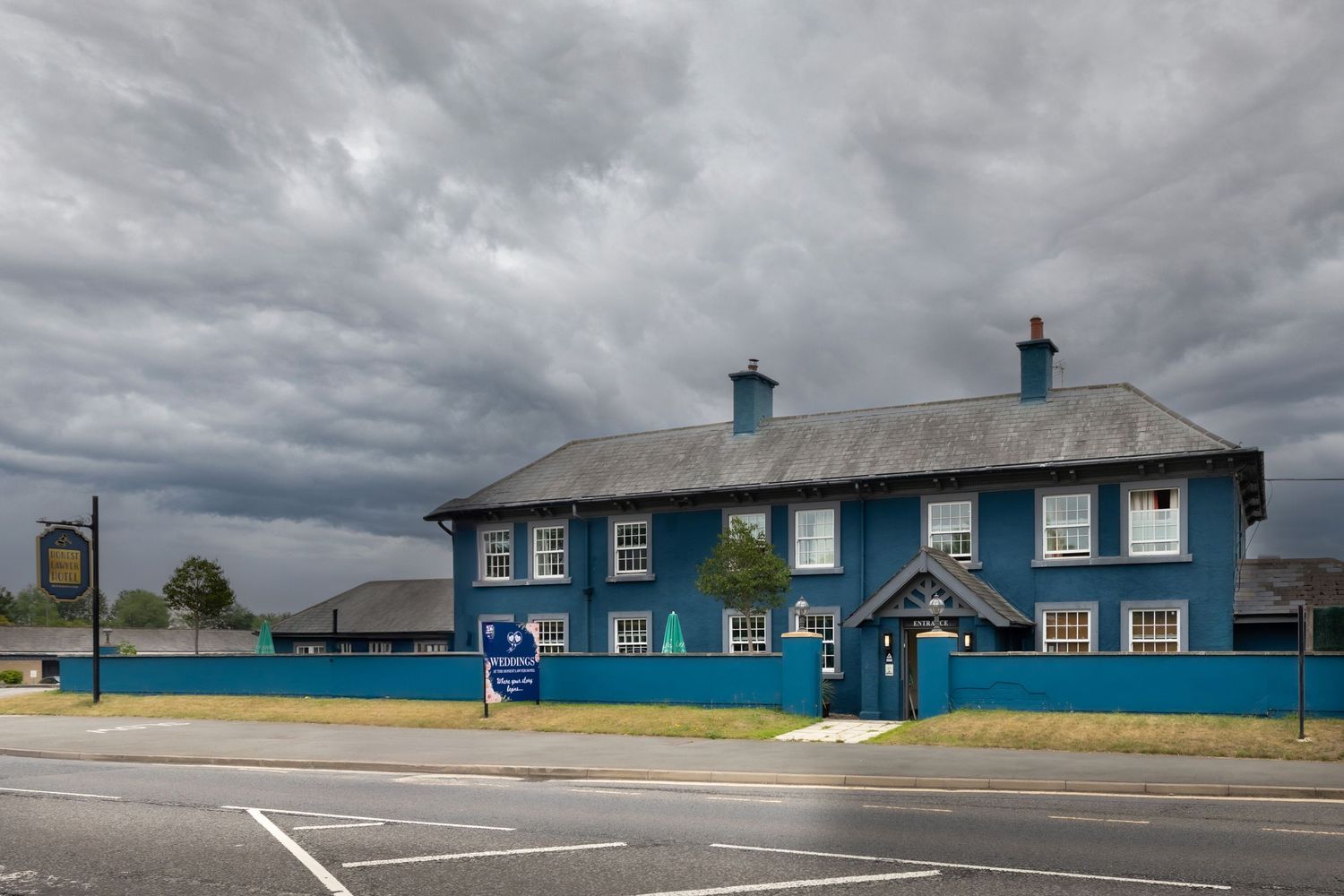 A long blue building with white trim sits under dramatic cloudy skies at a remote location. The Honest Lawyer Croxdale County Durham