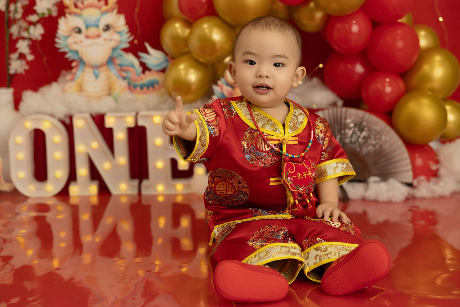 Traditional Chinese New Year celebration setup with red and gold decorations against a festive backdrop.