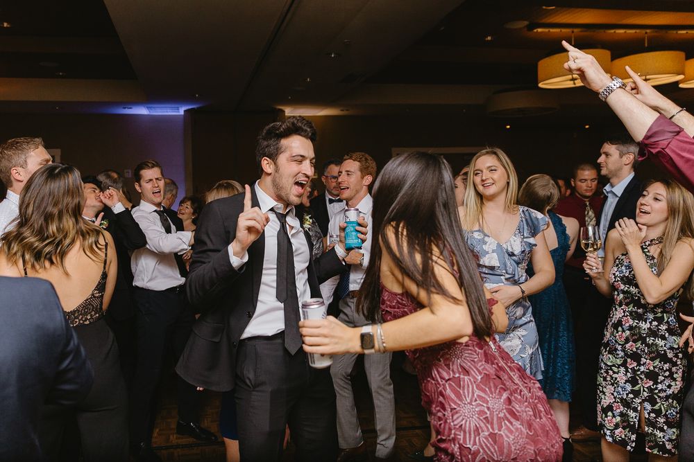 Guests dancing and celebrating at a lively wedding reception party on the dance floor.