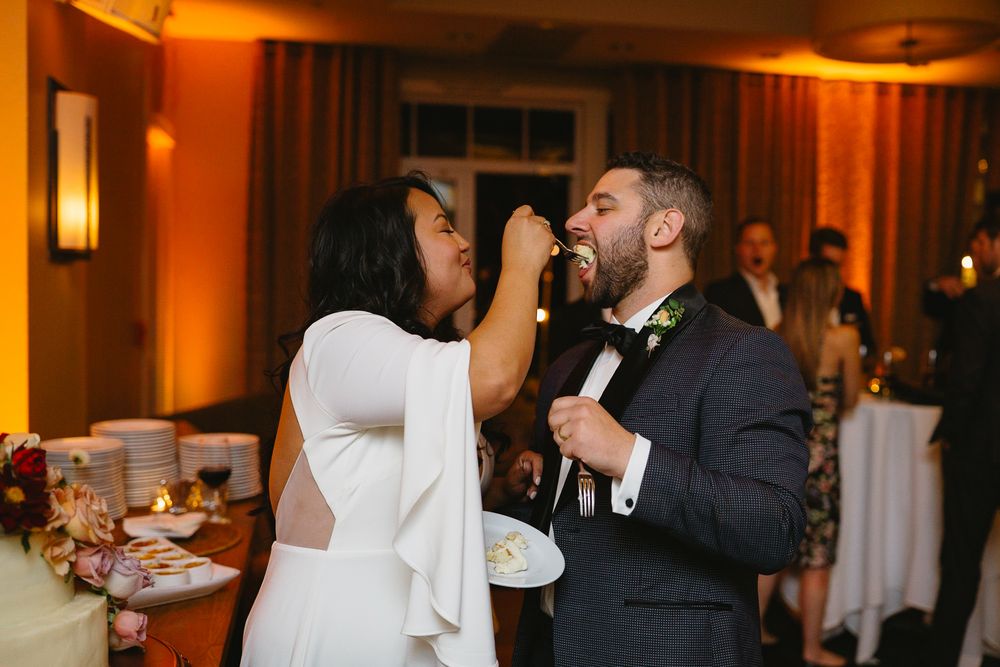 Wedding couple shares their first dance in a warmly lit ballroom during their reception celebration.