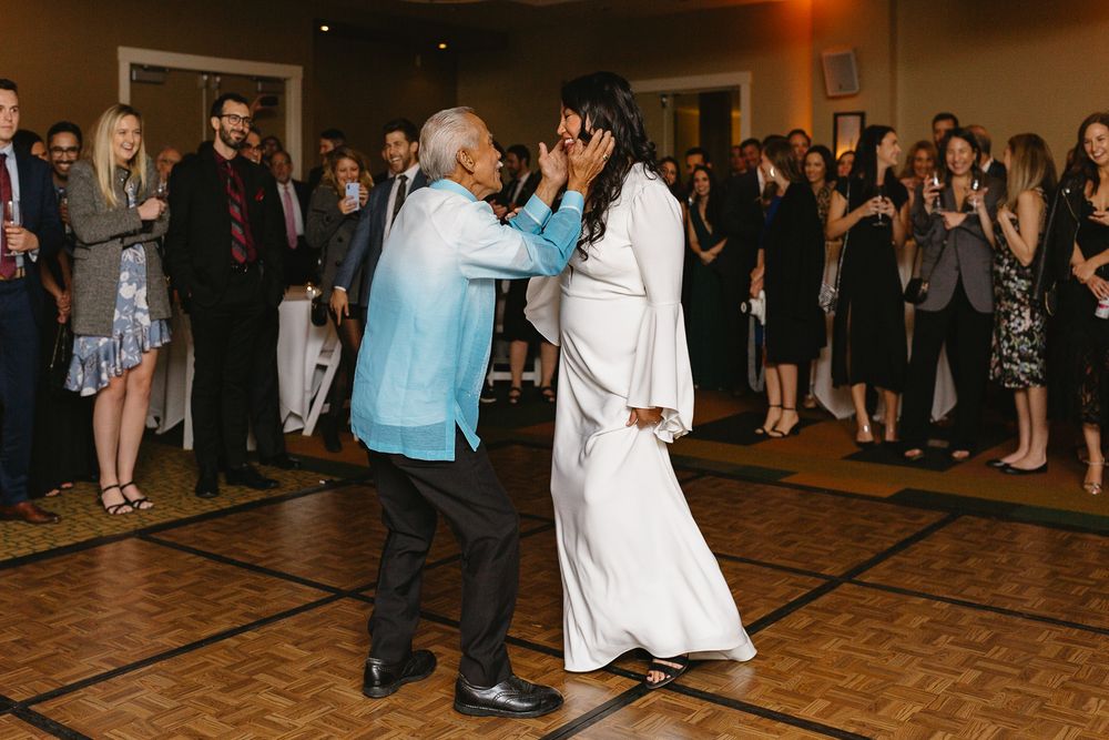 Wedding guests dance together on a wooden dance floor during an evening reception celebration.