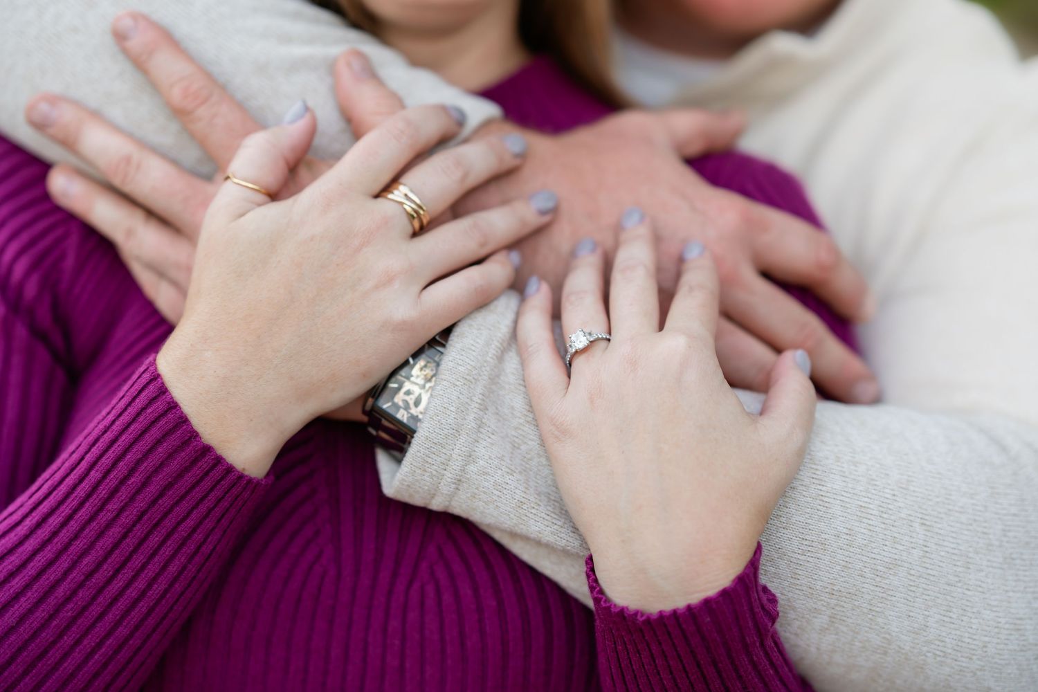 Close up of hands with engagement rings showing during a romantic outdoor photo session.