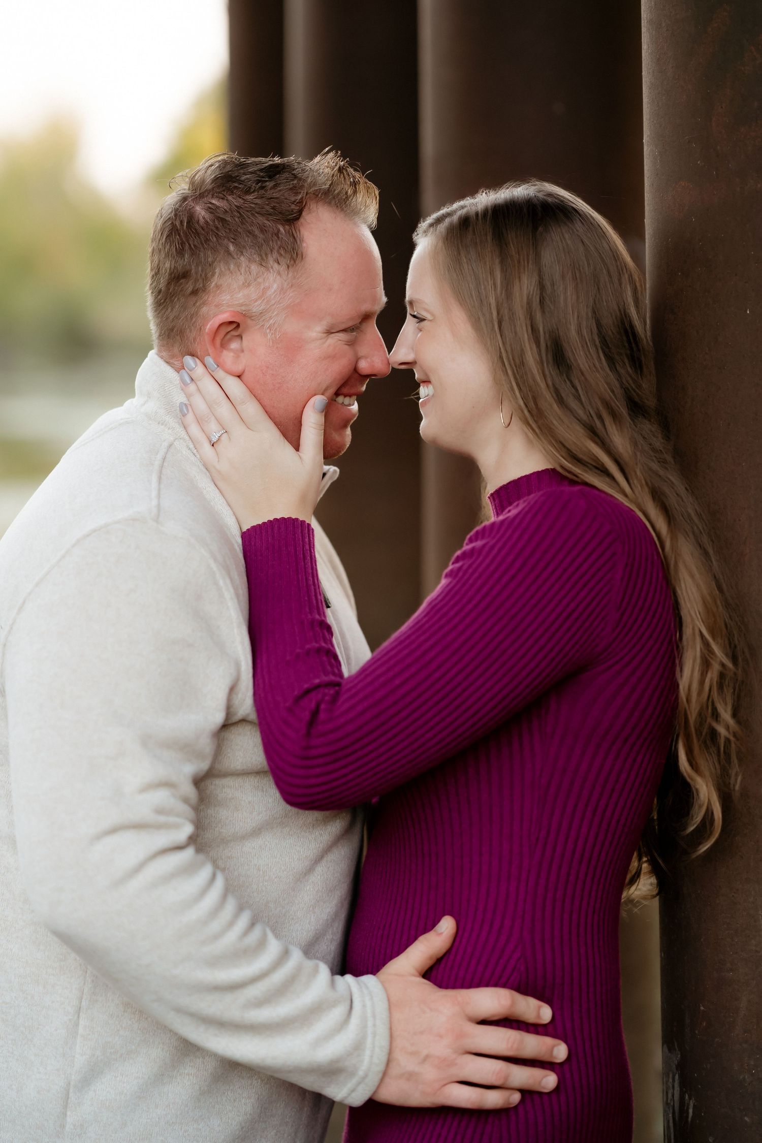 A couple in a white sweater and purple sweater share intimate moments in a romantic outdoor photoshoot series.