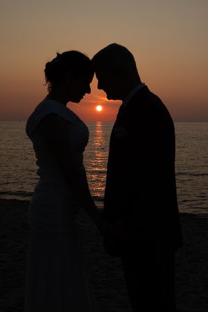Silhouetted couple sharing an intimate moment at sunset by Lake Michigan in Petosky, MI