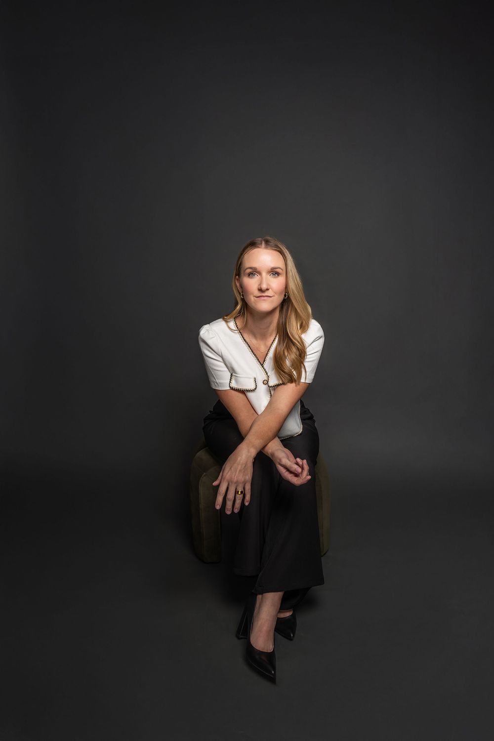 Dramatic studio portrait featuring business attire and artistic poses against dark background.
