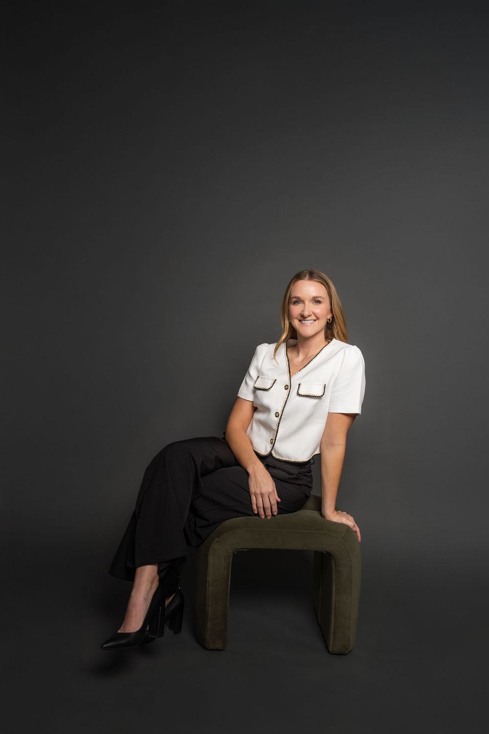 Modern portrait composition with olive green furniture and dramatic studio lighting.