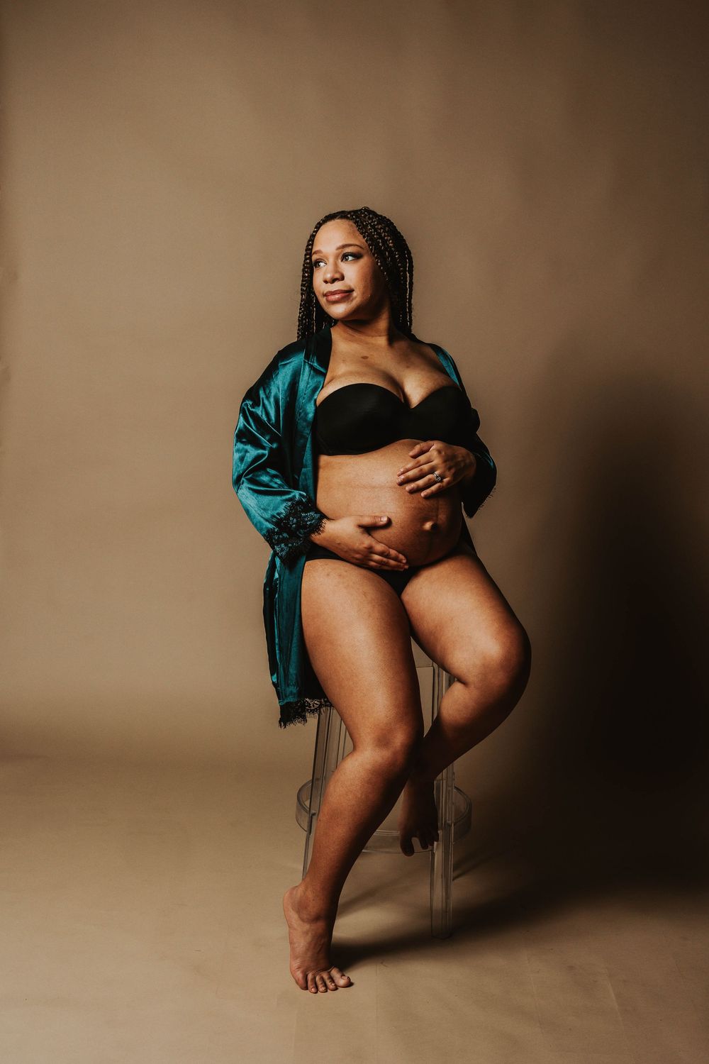 Artistic boudoir photography with teal silk robe in warm sepia tones.