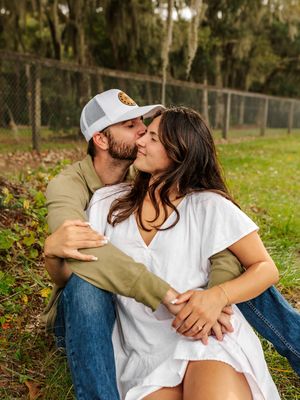 Affectionate couple sharing an intimate moment outdoors on grass.