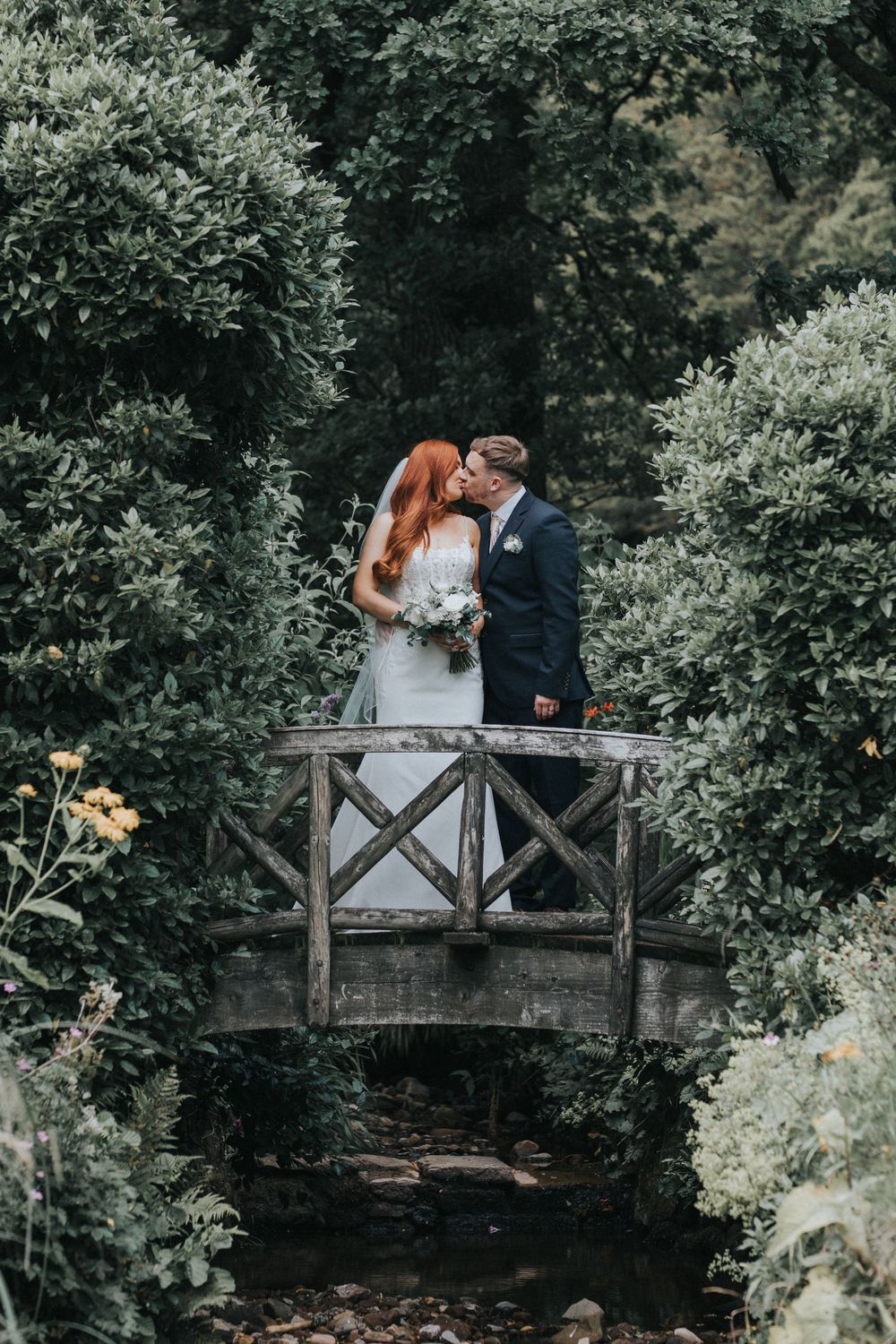 browsholme and the tithe barn wedding photography bride groom bridge kiss