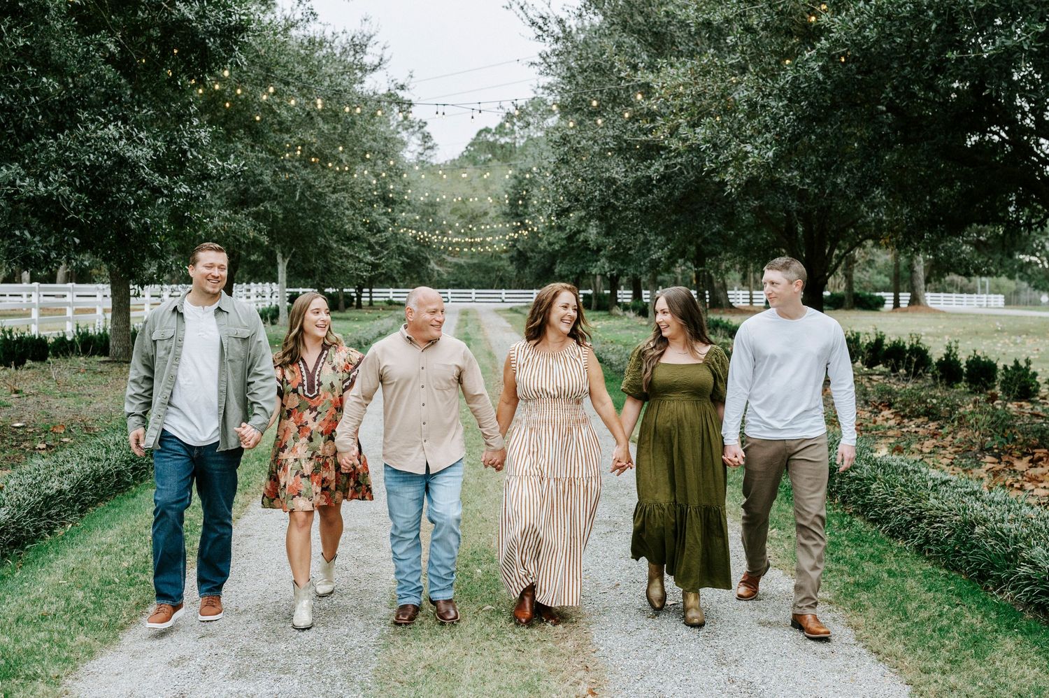 Group walking together along a tree-lined path in coordinated casual outfits.
