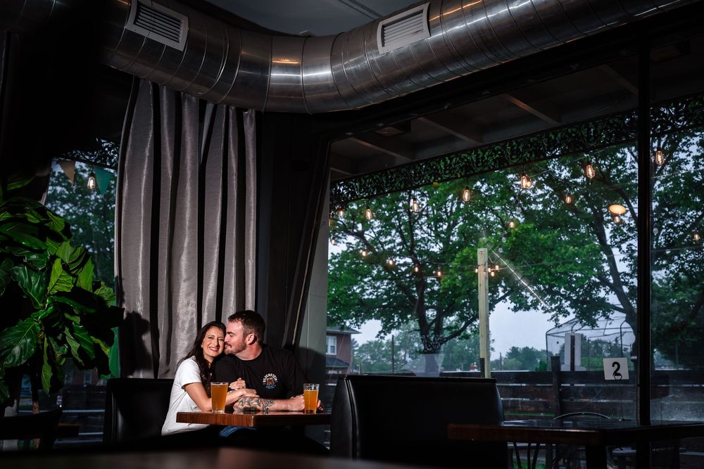 A dark and moody wedding photo session in an industrial venue with exposed ductwork and large windows.