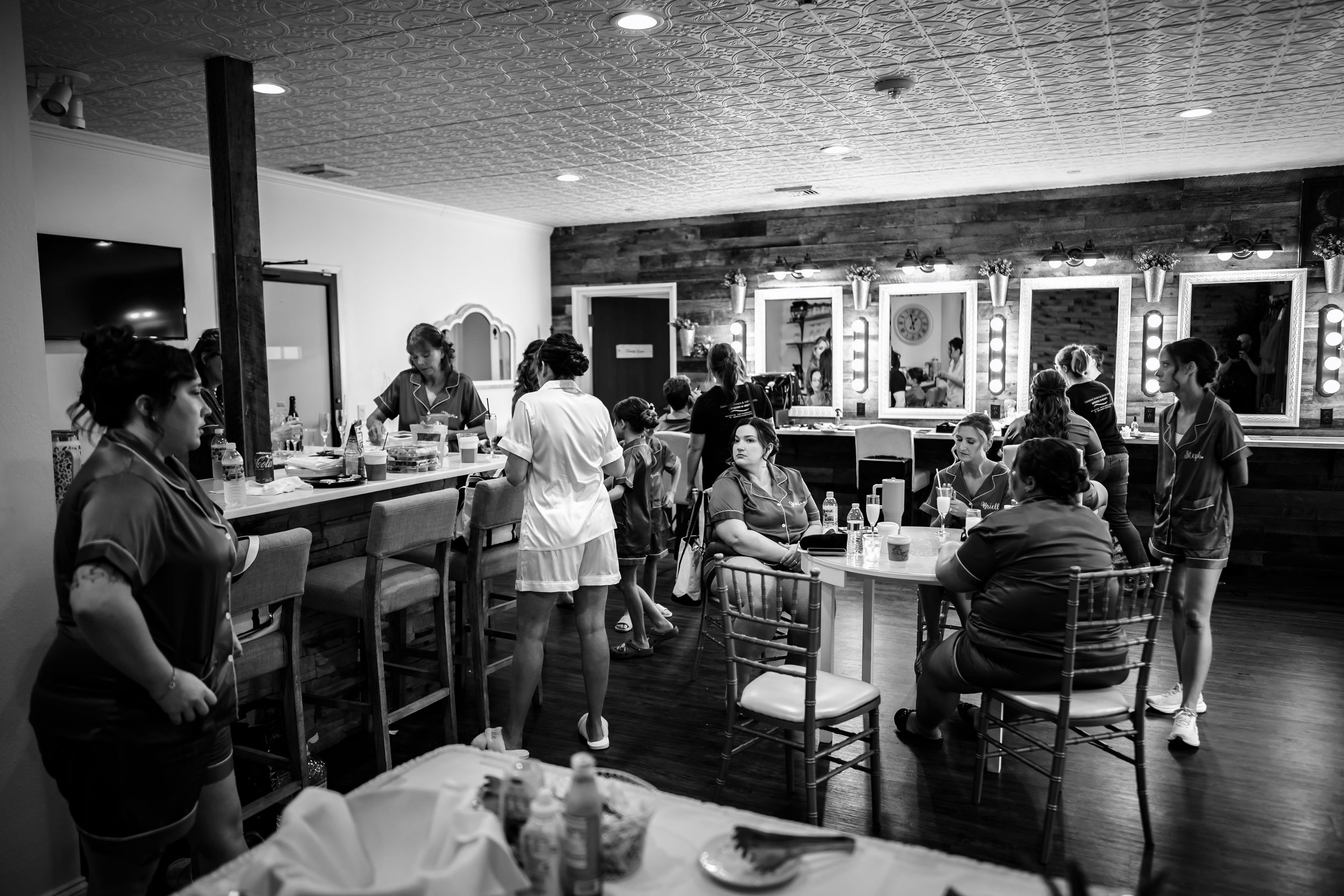 Wedding guests enjoying a reception in an elegant venue with tables and decor visible in the background.