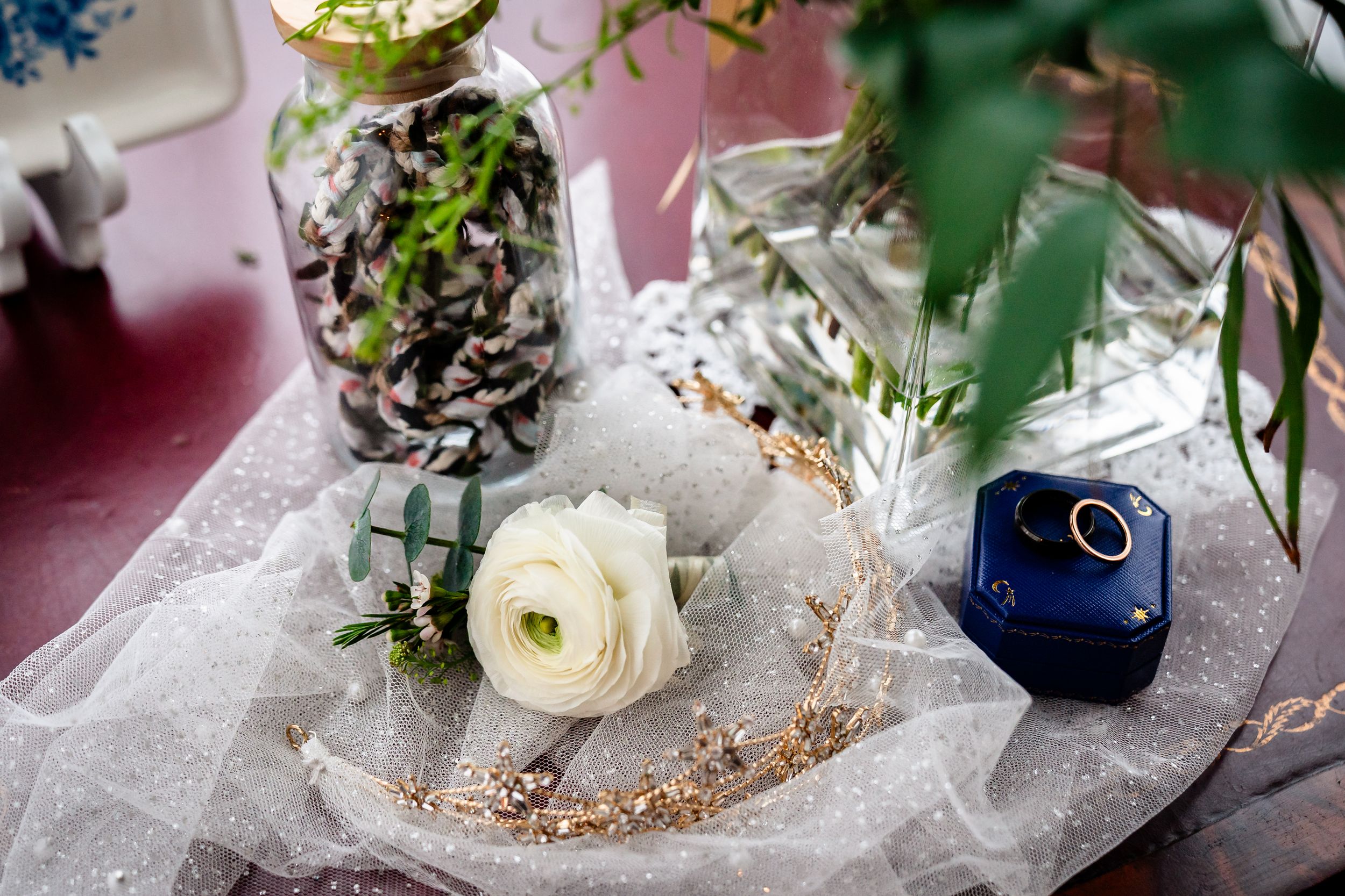 Wedding table decorations featuring delicate floral centerpieces with white flowers and green foliage on elegant place settings.