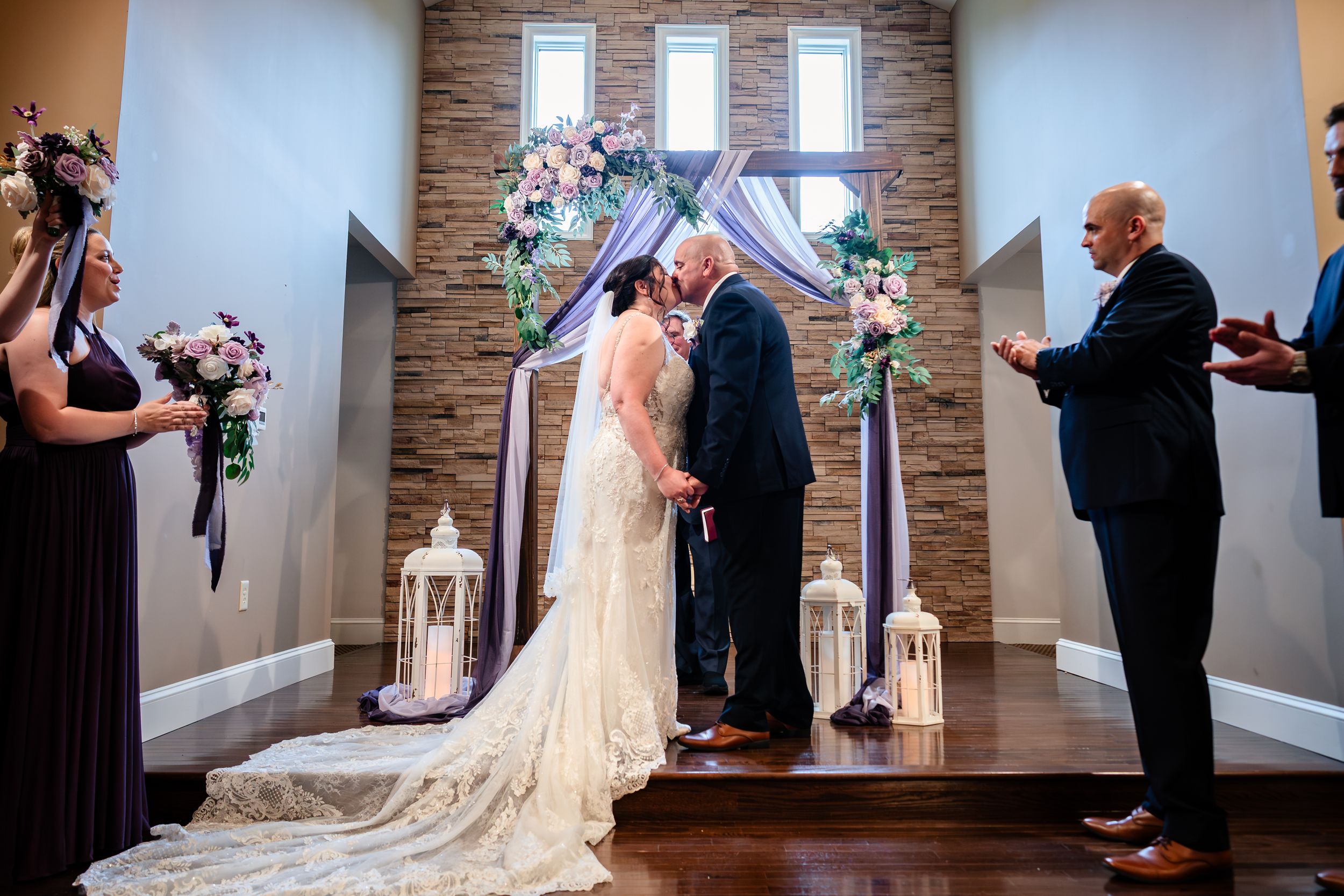 Indoor wedding ceremony in a modern chapel with stone accent walls and natural lighting.