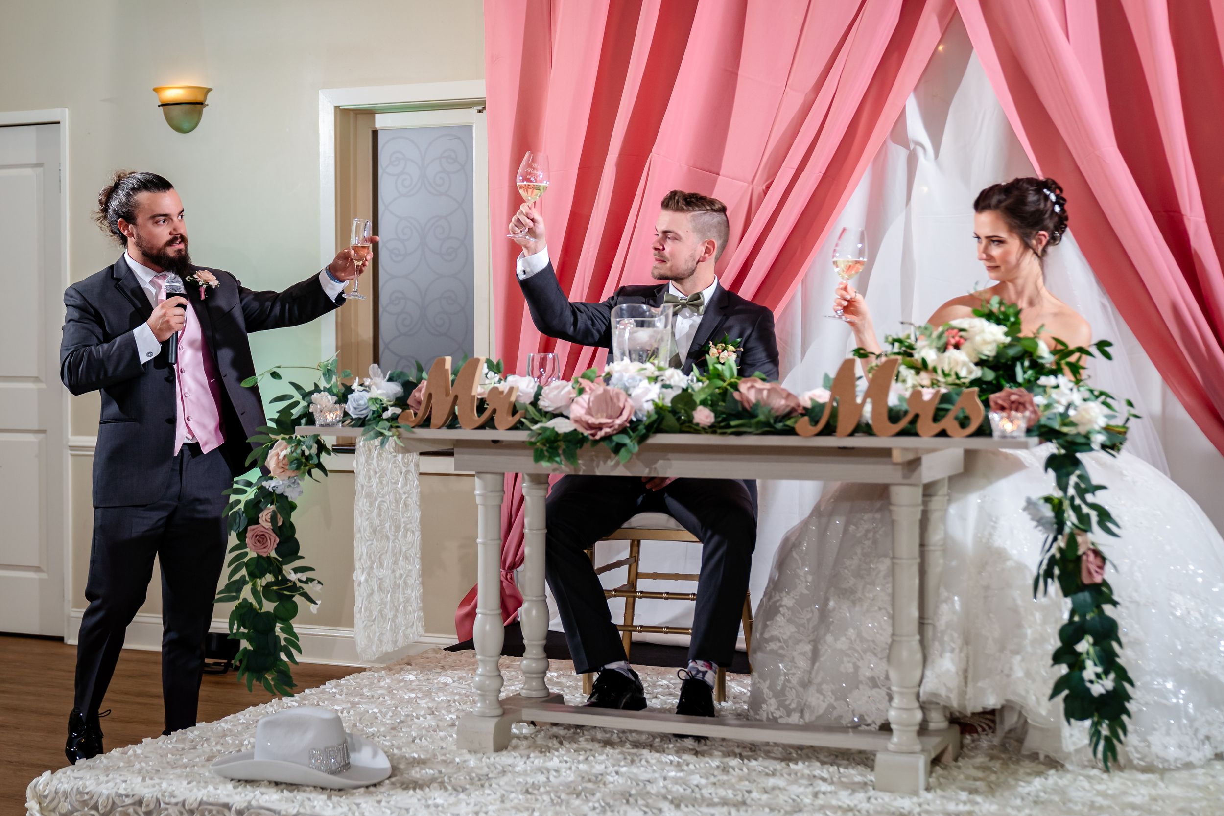 Wedding venue decorated with pink drapes and floral arrangements creating an elegant backdrop.