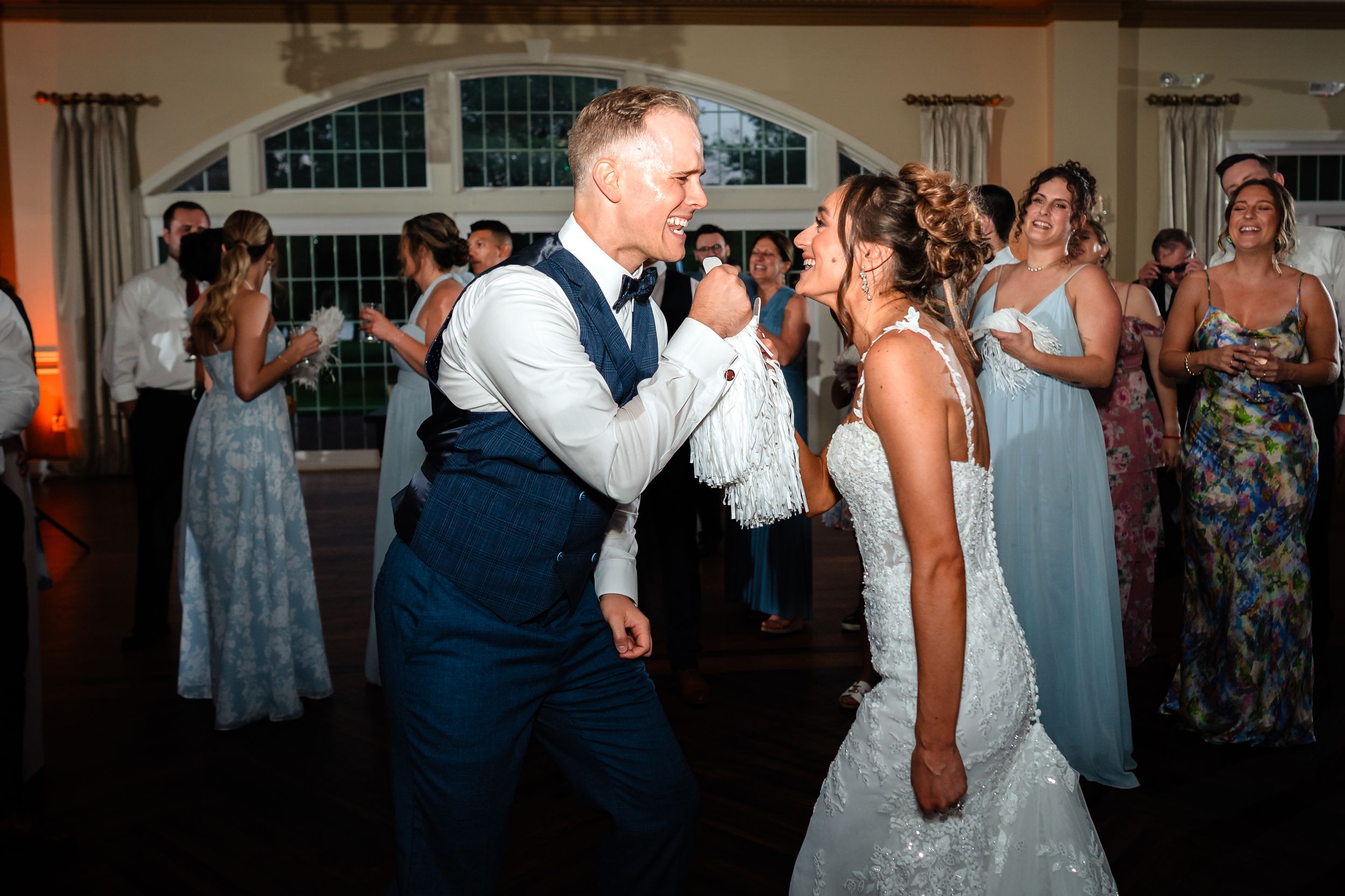 Wedding guests dance and celebrate together on a lively reception dance floor.