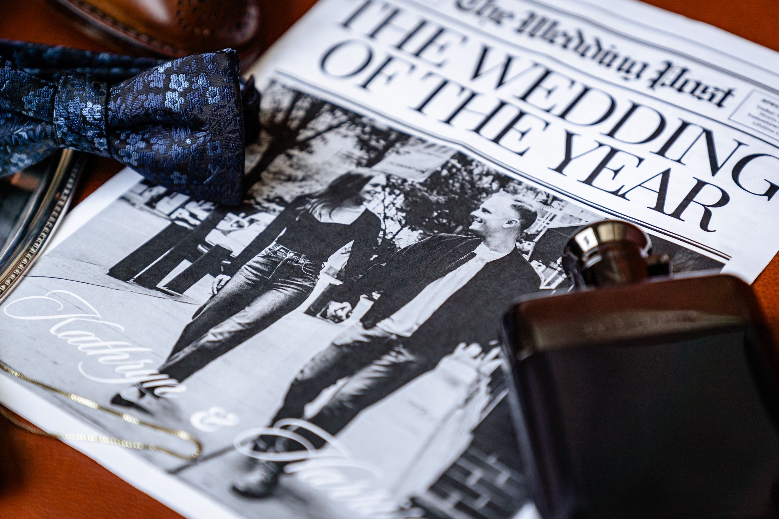 A collection of vintage black and white photographs and newspapers laid out on a wooden surface.