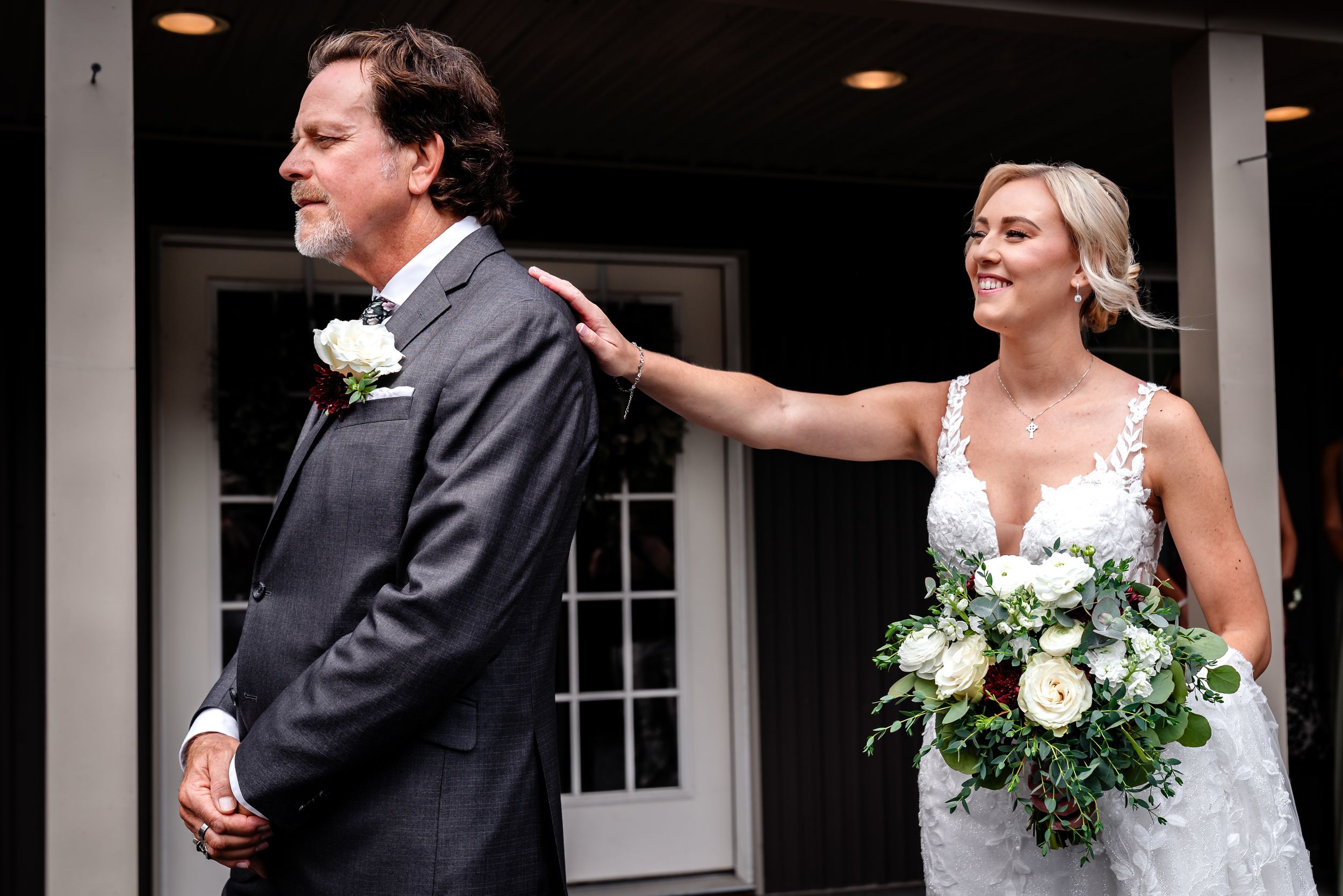 A bride and groom share a joyful moment together on their wedding day outside a building with white columns.