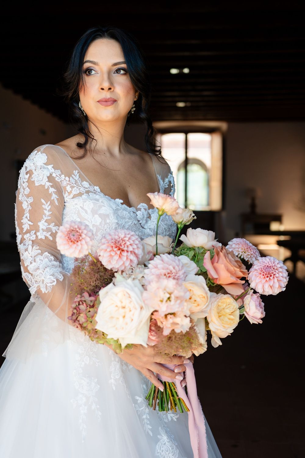 A wedding bouquet of pink and white flowers is held against a white lace dress in a sequence of detailed shots.