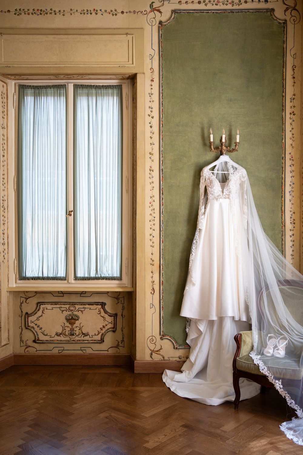 White flowing fabric hangs mysteriously in an ornate vintage room with green walls and decorative moldings.