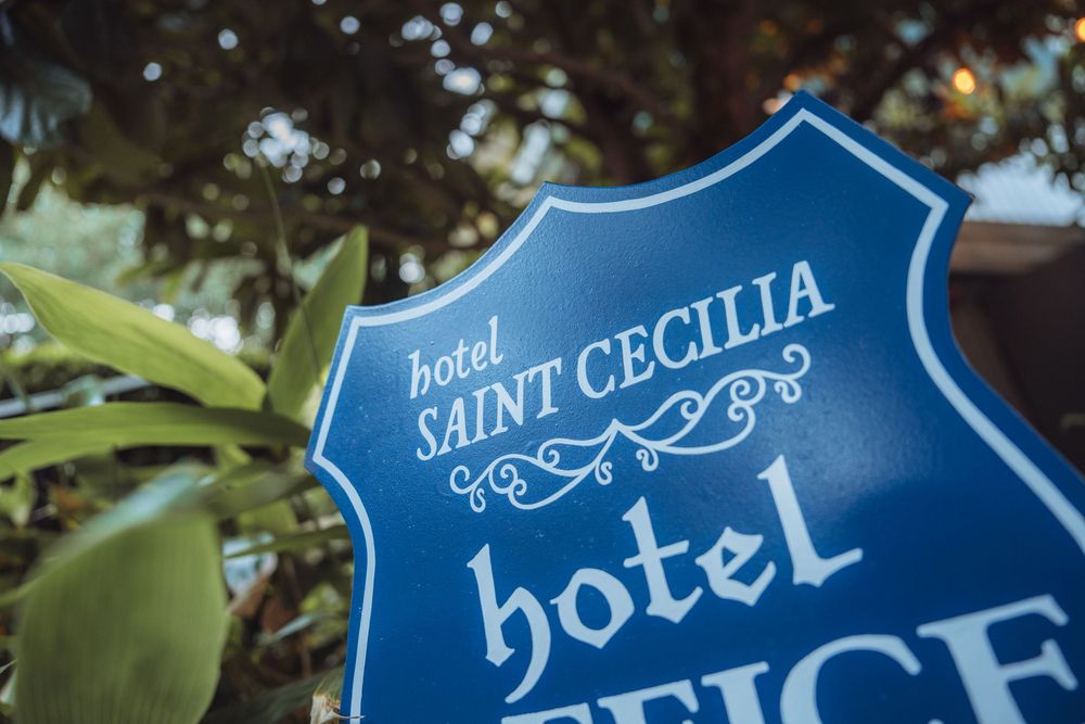 Blue vintage-style hotel signs mounted on posts against natural background.